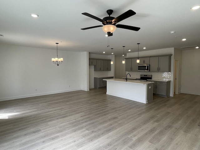 kitchen with gray cabinetry, light wood-style flooring, a sink, and appliances with stainless steel finishes