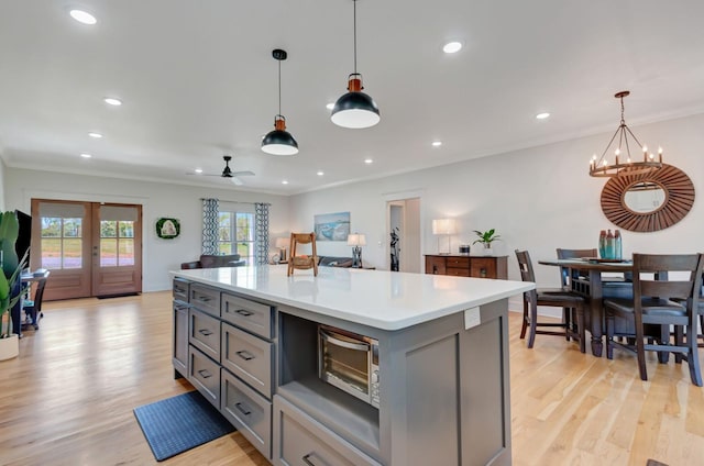 57 Watson Ct, Leoma, TN 38468 - kitchen with gray cabinetry, light wood-type flooring, light countertops, ornamental molding, and pendant lighting