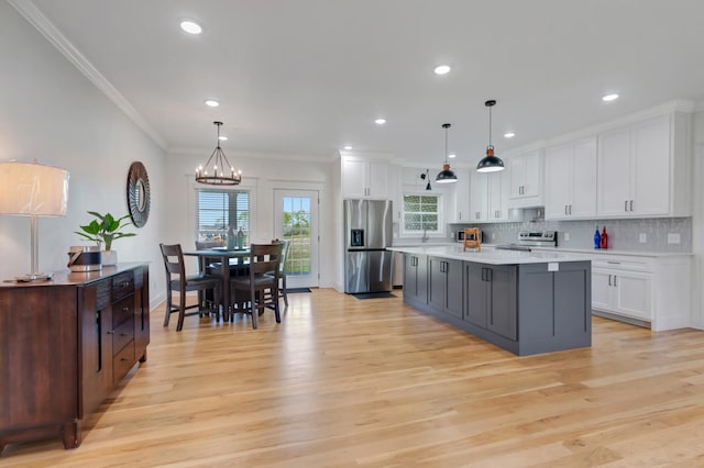 57 Watson Ct, Leoma, TN 38468 - kitchen with appliances with stainless steel finishes, white cabinetry, a chandelier, light wood-style floors, and ornamental molding