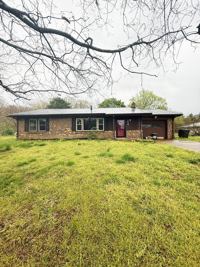 single story home with a front yard, a garage, a chimney, aphalt driveway, and brick siding