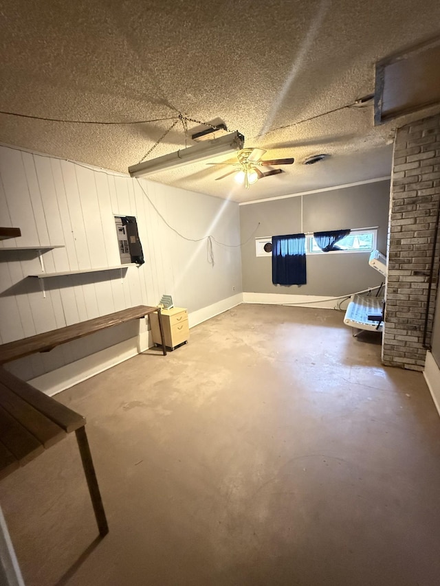basement with a textured ceiling and a ceiling fan
