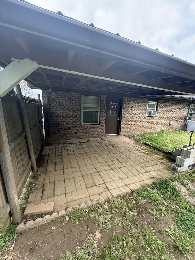 view of patio / terrace with a carport, cooling unit, and fence