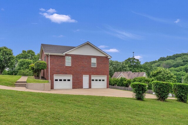 211 Northview Ct, Hendersonville, TN 37075 - view of side of home featuring brick siding, a garage, driveway, and a yard