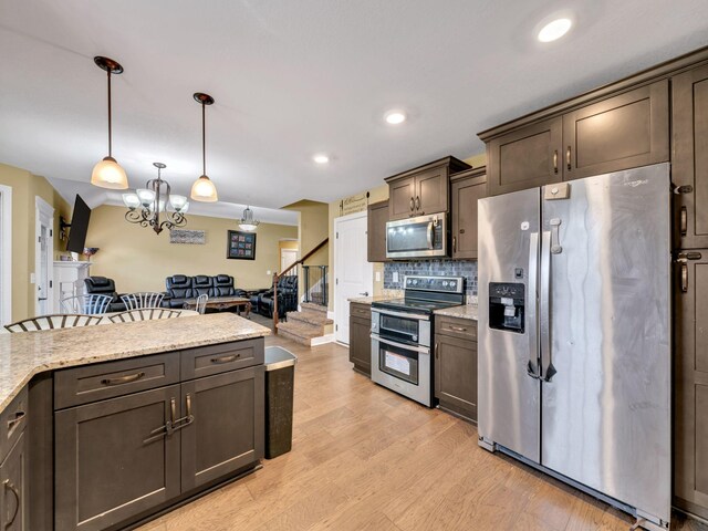 1084 Harrison Way, Clarksville, TN 37042 - kitchen featuring dark brown cabinetry, pendant lighting, stainless steel appliances, light wood-style flooring, and backsplash