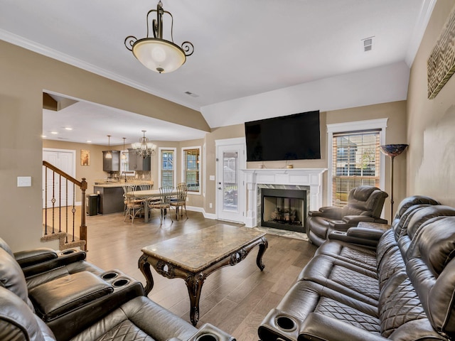 1084 Harrison Way, Clarksville, TN 37042 - living room with visible vents, an inviting chandelier, a premium fireplace, wood finished floors, and stairway