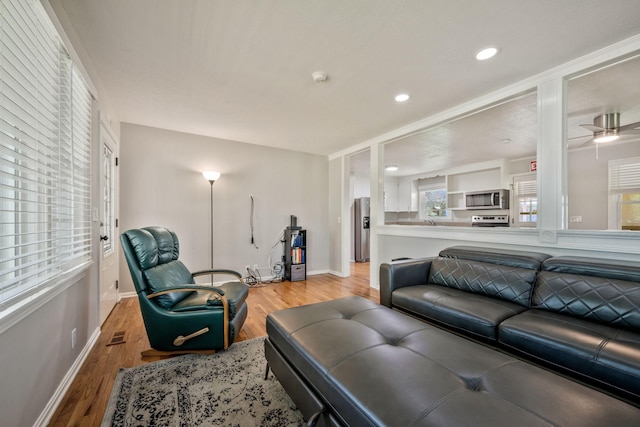 living area featuring wood finished floors, baseboards, and recessed lighting