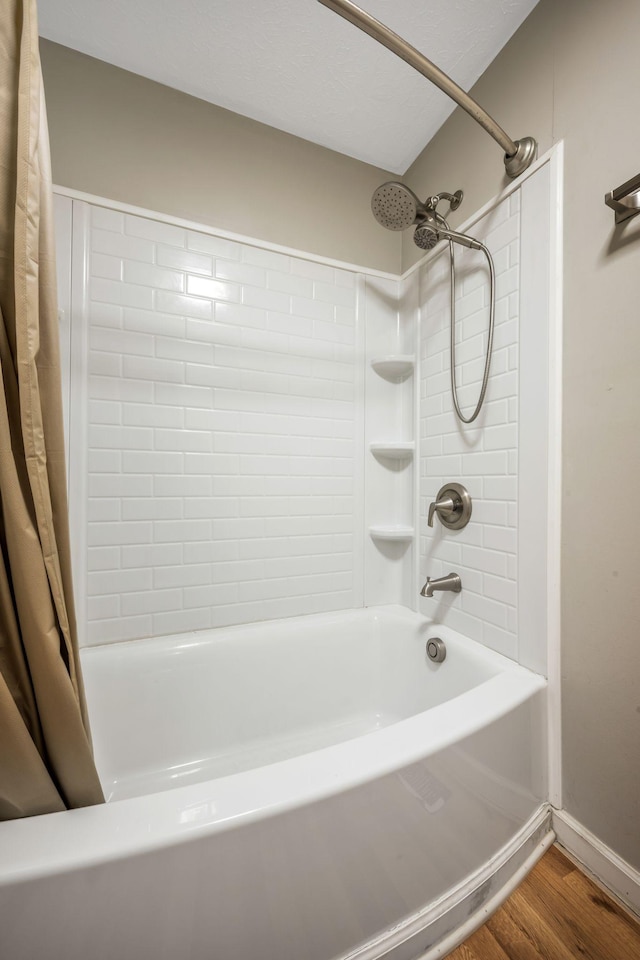 bathroom with shower / tub combo with curtain, baseboards, and wood finished floors