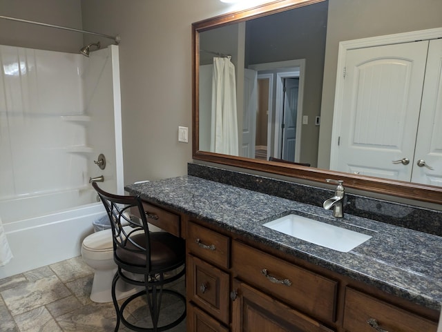 bathroom featuring shower / bath combination with curtain, vanity, stone tile flooring, and toilet