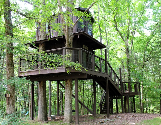 view of outbuilding featuring stairway and a view of trees