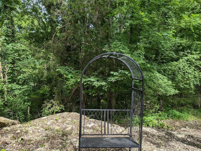 exterior details with a forest view, a gate, and a sink