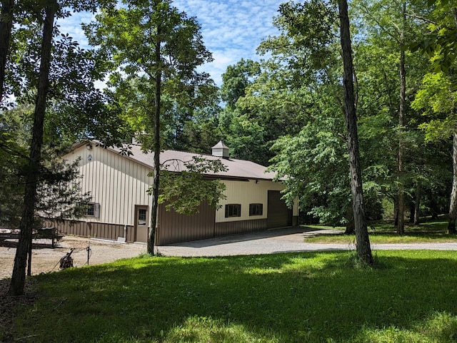 exterior space featuring a pole building, an outdoor structure, and a lawn