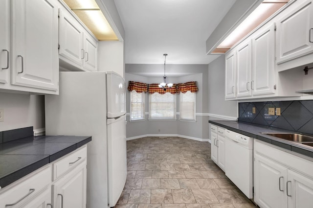 kitchen with a notable chandelier, white appliances, stone finish floor, tile counters, and white cabinetry