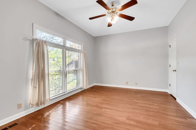 spare room with visible vents, ceiling fan, light wood-type flooring, and baseboards
