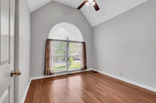 spare room featuring baseboards, wood-type flooring, a ceiling fan, and lofted ceiling