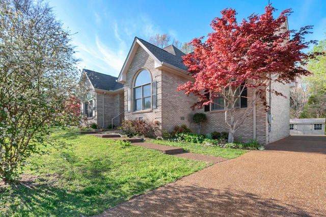 view of front of property featuring brick siding and a front lawn