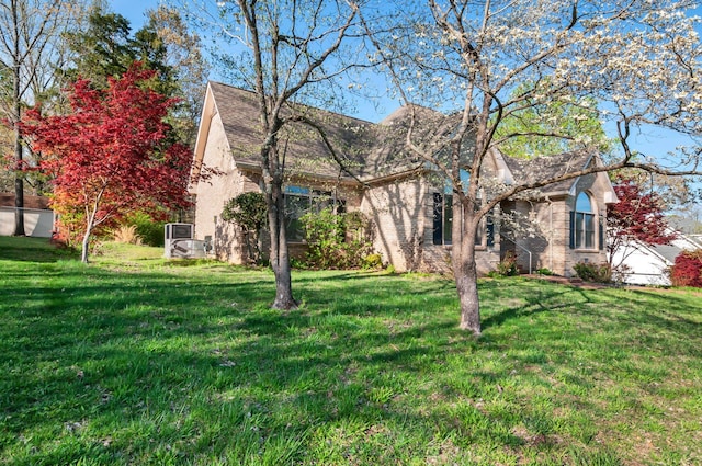 view of front of house with brick siding and a front lawn