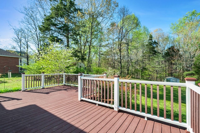 wooden deck featuring an outbuilding, a storage unit, and a yard