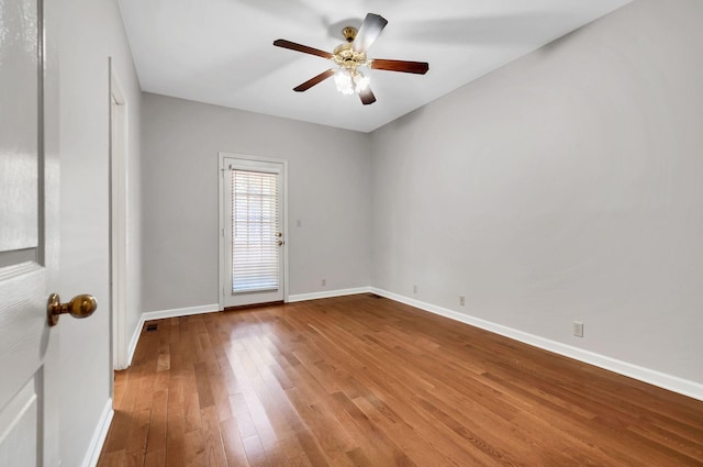 empty room with baseboards, a ceiling fan, and wood finished floors