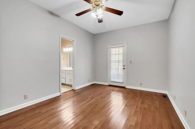 spare room featuring baseboards, a ceiling fan, and hardwood / wood-style flooring