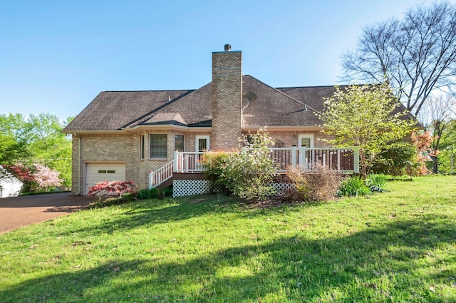 back of house with a lawn, brick siding, a chimney, driveway, and a deck