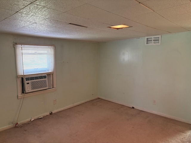 carpeted spare room featuring visible vents, cooling unit, and baseboards