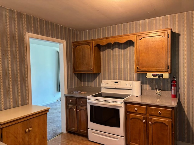 kitchen featuring light countertops, white range with electric cooktop, and wallpapered walls