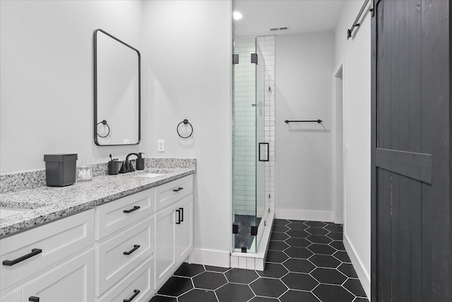 bathroom with a shower stall, tile patterned flooring, visible vents, a sink, and double vanity