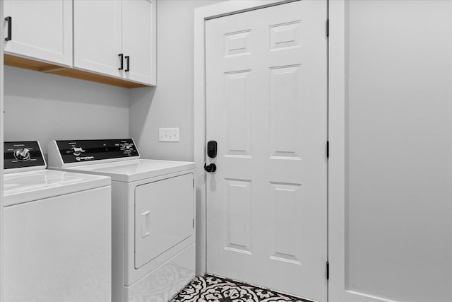 clothes washing area featuring washer and clothes dryer and cabinet space