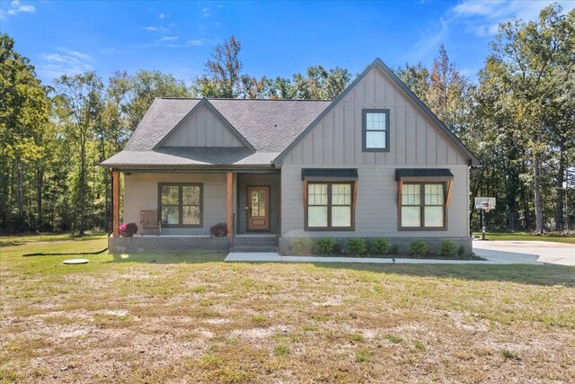 modern inspired farmhouse featuring board and batten siding, a front lawn, and a shingled roof