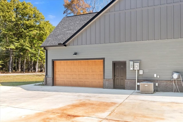 garage with concrete driveway and central air condition unit