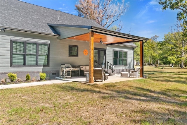 rear view of property featuring a patio, a lawn, crawl space, ceiling fan, and a shingled roof