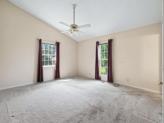 empty room featuring a textured ceiling, lofted ceiling, a ceiling fan, and carpet