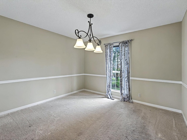 carpeted empty room with baseboards and a textured ceiling