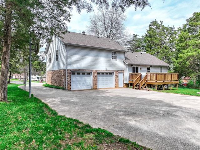 view of property exterior featuring a deck, a garage, brick siding, driveway, and roof with shingles