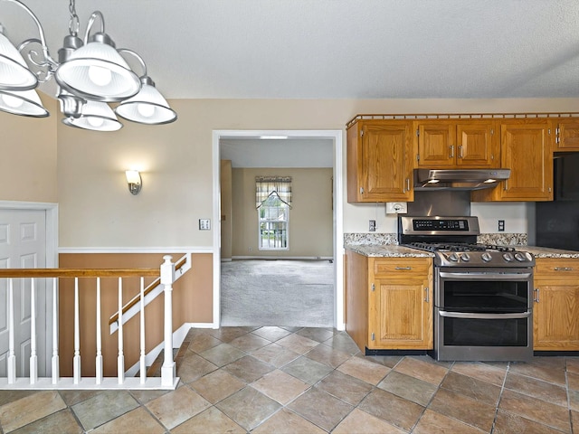 kitchen with a textured ceiling, double oven range, carpet floors, under cabinet range hood, and baseboards