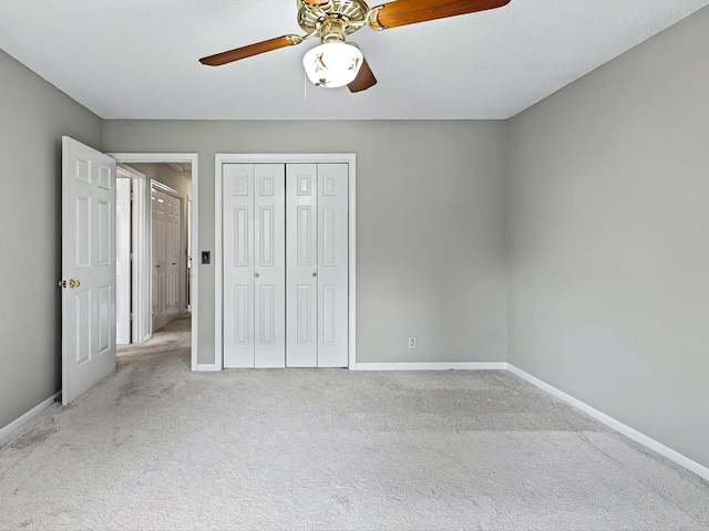 unfurnished bedroom featuring carpet flooring, a closet, baseboards, and ceiling fan
