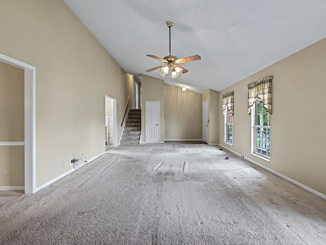 unfurnished living room featuring baseboards, ceiling fan, a textured ceiling, stairway, and carpet flooring