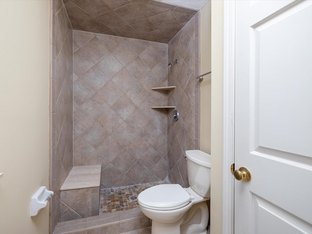 full bath featuring a tile shower and toilet