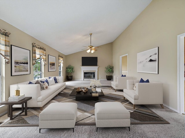 living area featuring a glass covered fireplace, baseboards, a ceiling fan, high vaulted ceiling, and carpet