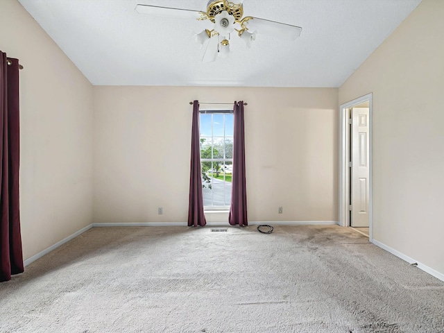 carpeted empty room featuring visible vents, baseboards, and a ceiling fan