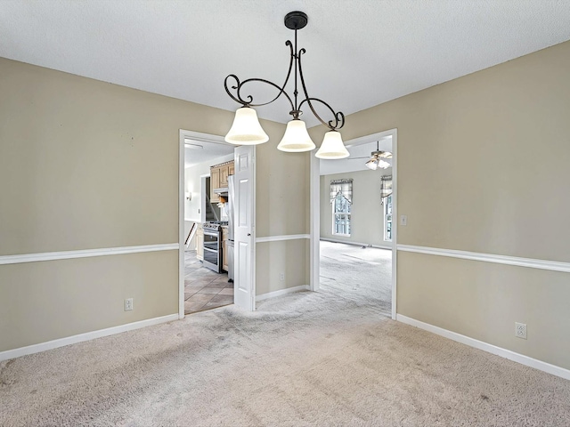 unfurnished room with carpet flooring, baseboards, a textured ceiling, and ceiling fan