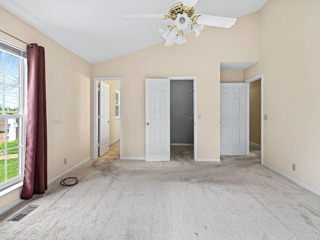 unfurnished bedroom featuring carpet flooring, visible vents, multiple windows, and lofted ceiling