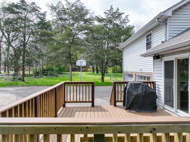 wooden terrace featuring grilling area and a lawn