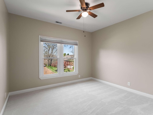 unfurnished room featuring light carpet, baseboards, a ceiling fan, and visible vents