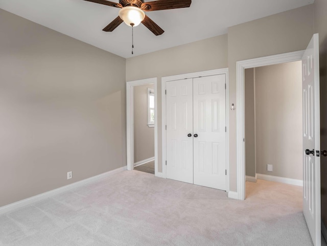 unfurnished bedroom featuring carpet flooring, a closet, baseboards, and a ceiling fan