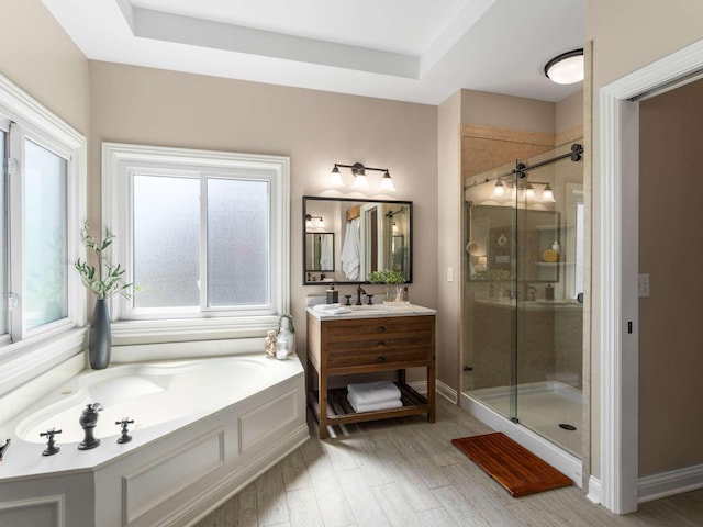 full bathroom with baseboards, vanity, wood finished floors, a stall shower, and a garden tub