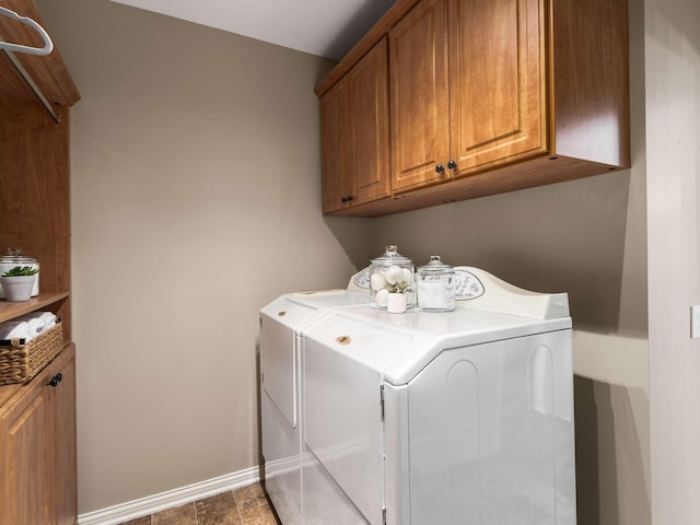 laundry room featuring independent washer and dryer, baseboards, and cabinet space