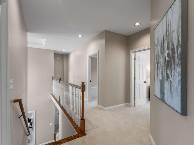 hallway featuring light carpet, baseboards, an upstairs landing, and recessed lighting