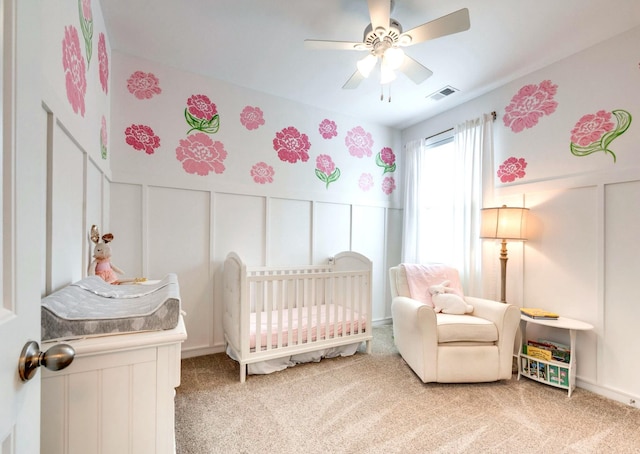 627 Prominence Rd, Columbia, TN 38401 - carpeted bedroom with a decorative wall, a nursery area, wainscoting, and a ceiling fan