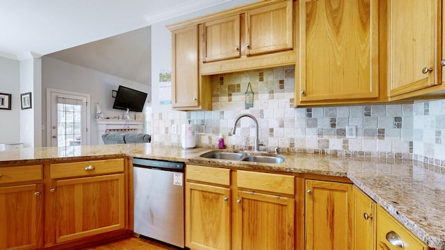 kitchen featuring dishwasher, decorative backsplash, light stone counters, and a sink